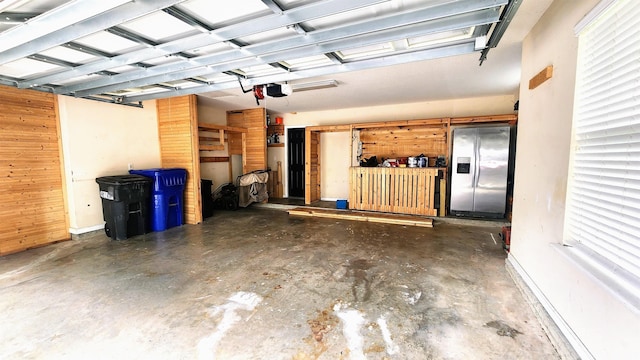 garage with stainless steel fridge with ice dispenser, a garage door opener, and water heater