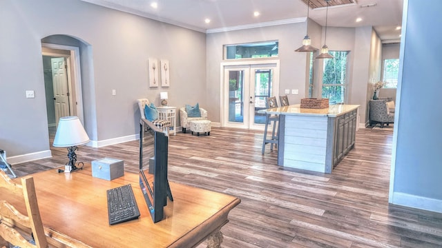 dining area featuring arched walkways, baseboards, crown molding, french doors, and wood finished floors