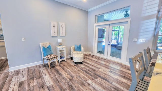 sitting room with crown molding, wood finished floors, french doors, and baseboards