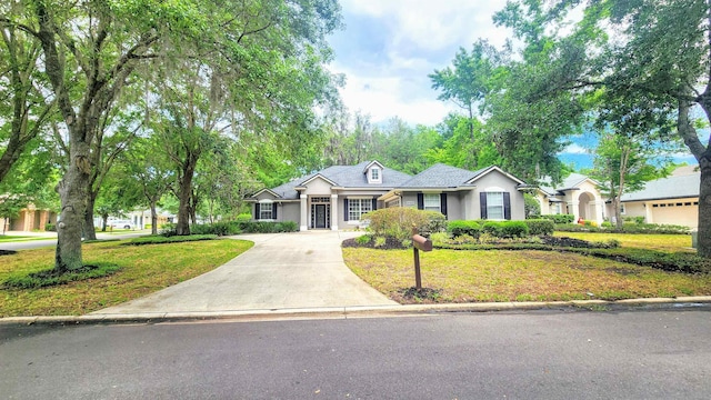 ranch-style house featuring a front yard, concrete driveway, and stucco siding