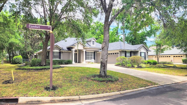 ranch-style home with a garage, stucco siding, driveway, and a front lawn
