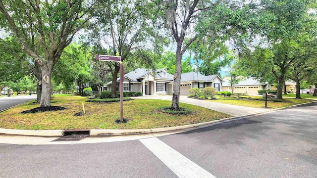ranch-style house featuring a front lawn, concrete driveway, and a garage