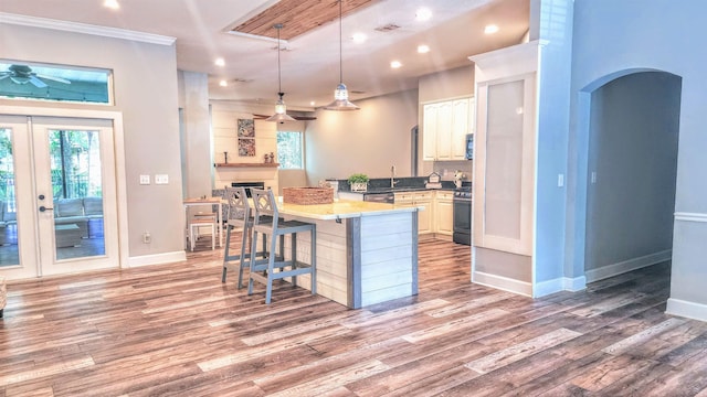 kitchen with a kitchen breakfast bar, ceiling fan, plenty of natural light, light wood-type flooring, and recessed lighting