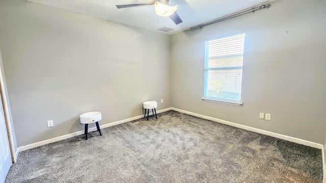 carpeted empty room with ceiling fan and baseboards