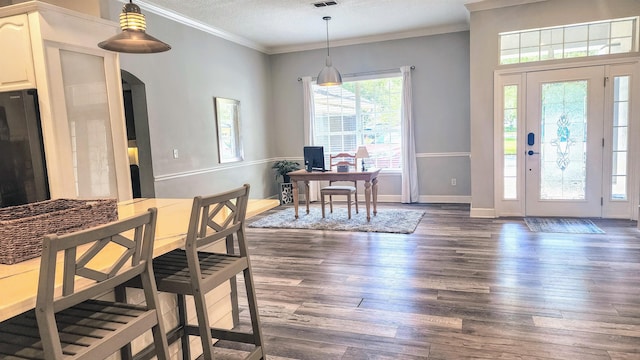 dining space with dark wood finished floors, arched walkways, ornamental molding, a textured ceiling, and a desk