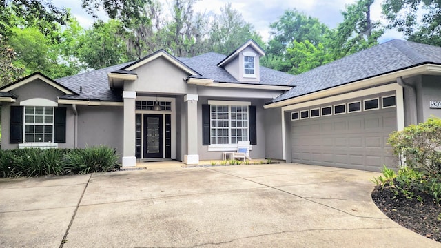 view of front of house featuring stucco siding, an attached garage, concrete driveway, and roof with shingles