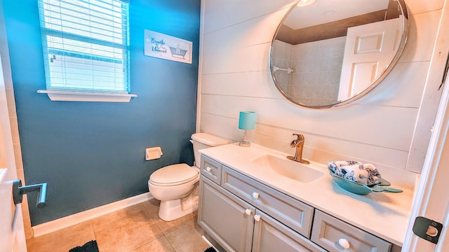 bathroom featuring tile patterned flooring, vanity, baseboards, and toilet