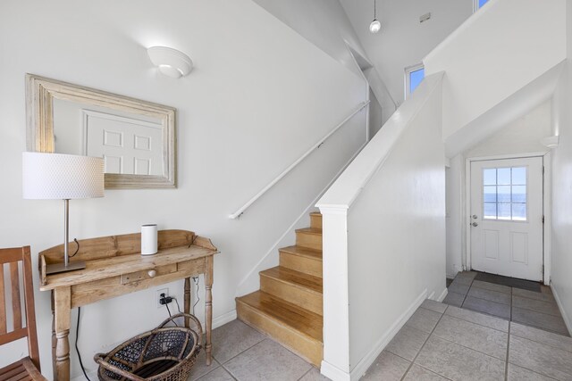 stairway with tile patterned floors and baseboards