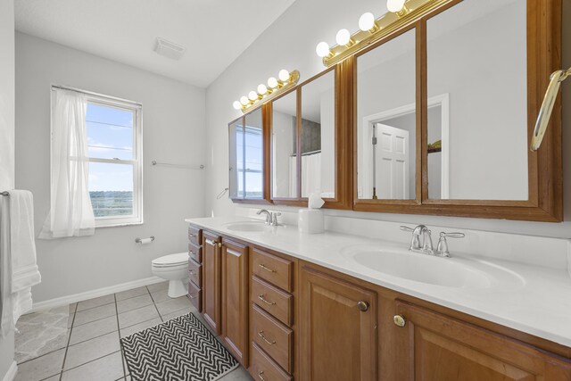 bathroom featuring tile patterned flooring, visible vents, toilet, double vanity, and a sink