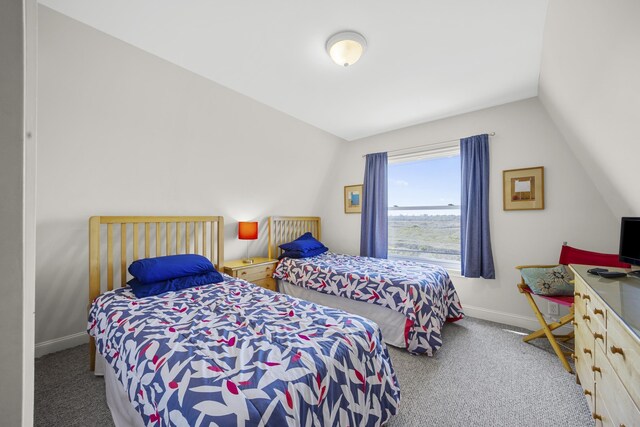 carpeted bedroom with vaulted ceiling and baseboards