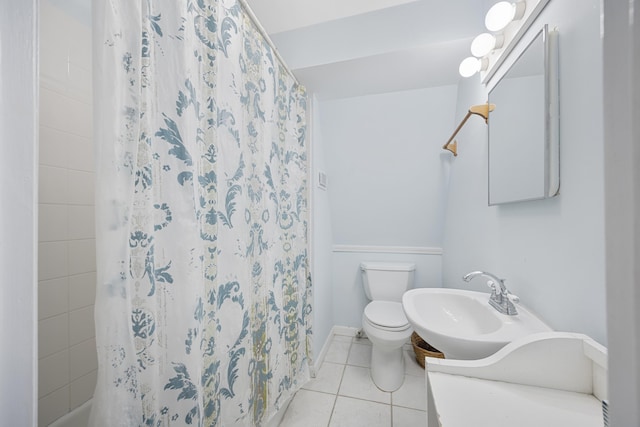 bathroom with tile patterned floors, toilet, and a sink