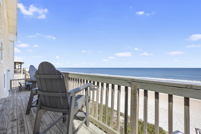 deck featuring a beach view and a water view