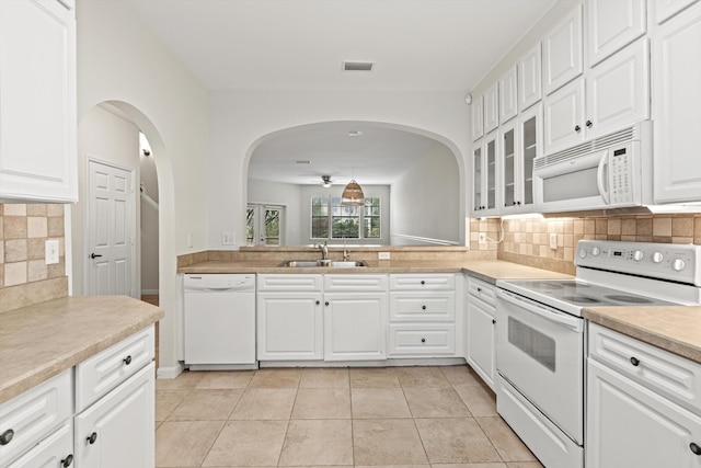 4515 Serena Cir, Saint Augustine, FL 32084 - kitchen with white appliances, a sink, arched walkways, visible vents, and glass insert cabinets