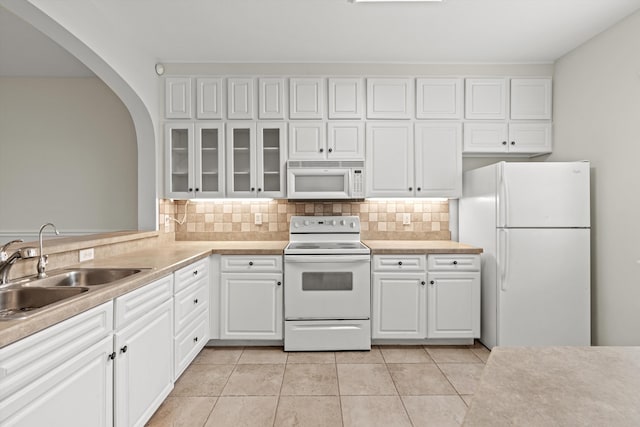 4515 Serena Cir, Saint Augustine, FL 32084 - kitchen featuring white cabinets, white appliances, tasteful backsplash, arched walkways, and a sink