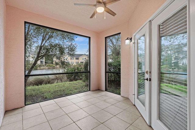 unfurnished sunroom featuring a water view and ceiling fan