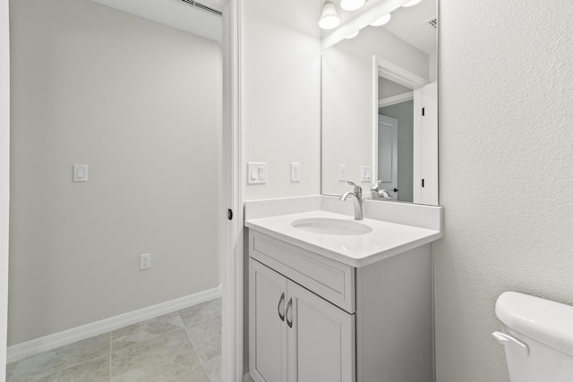 bathroom featuring tile patterned floors, vanity, and toilet