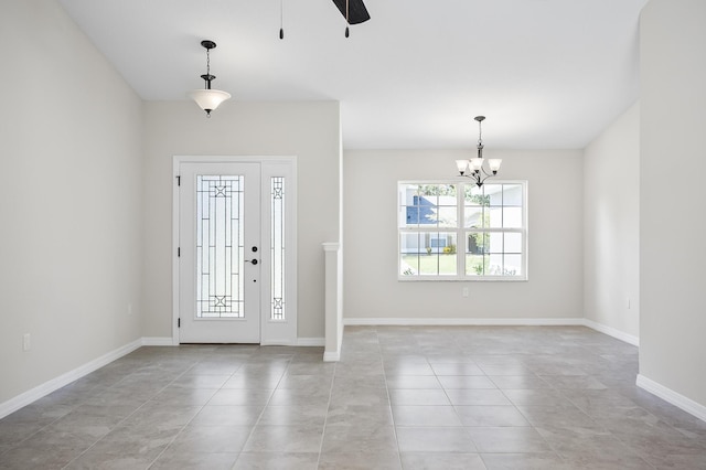 entryway featuring light tile patterned floors and ceiling fan with notable chandelier