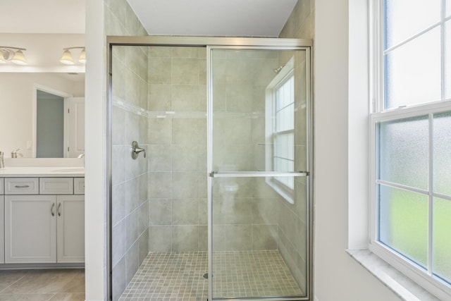 bathroom with vanity, a healthy amount of sunlight, and a shower with shower door