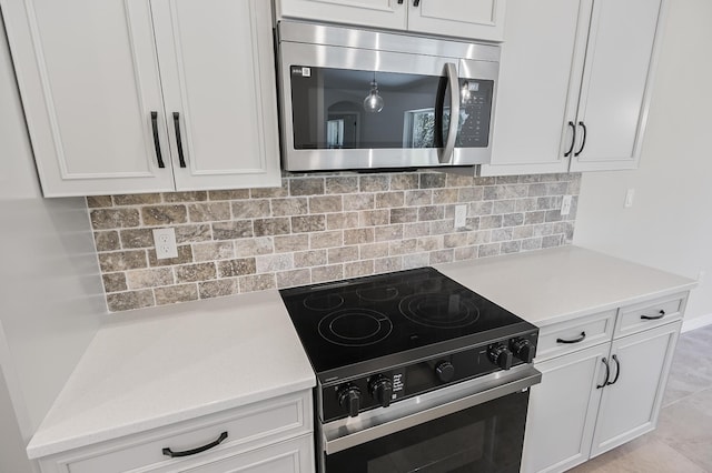 kitchen featuring light tile patterned flooring, white cabinetry, appliances with stainless steel finishes, and tasteful backsplash