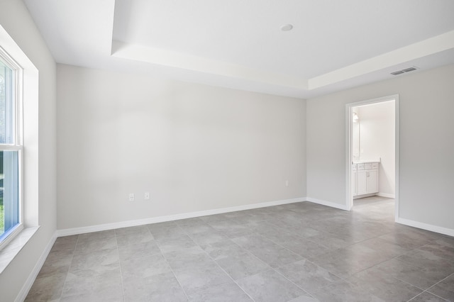 empty room featuring a raised ceiling