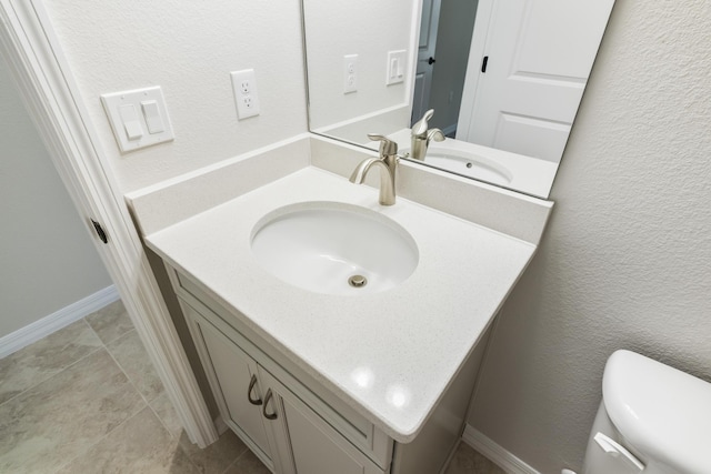 bathroom featuring tile patterned flooring, vanity, and toilet