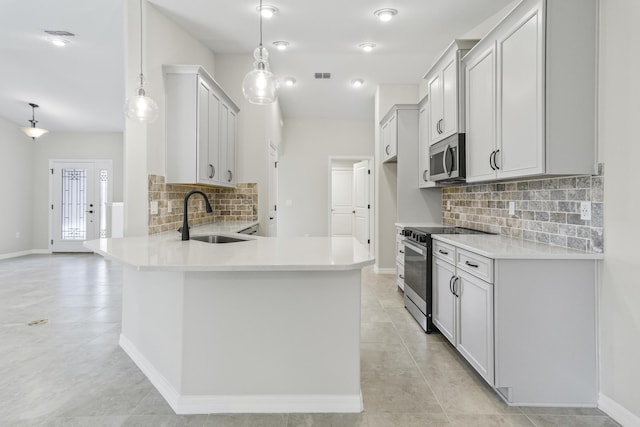 kitchen featuring pendant lighting, sink, decorative backsplash, kitchen peninsula, and stainless steel appliances