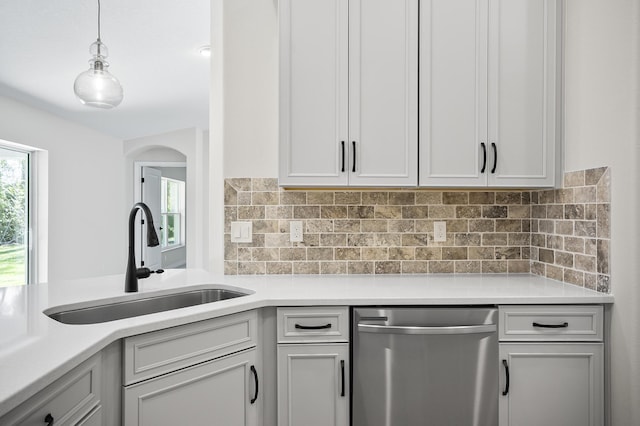 kitchen with white cabinetry, dishwasher, sink, pendant lighting, and decorative backsplash