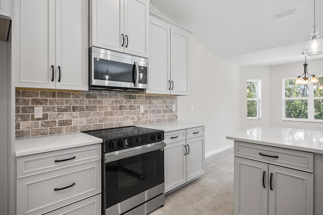 kitchen featuring hanging light fixtures, decorative backsplash, light tile patterned flooring, stainless steel appliances, and a chandelier