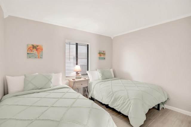 bedroom with crown molding and light wood-type flooring