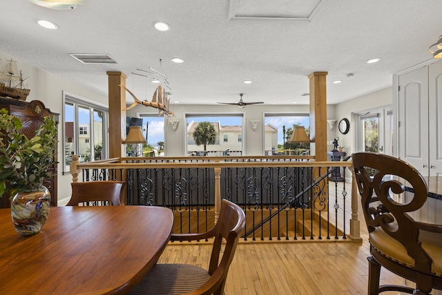 dining space with ceiling fan, plenty of natural light, light hardwood / wood-style floors, and a textured ceiling