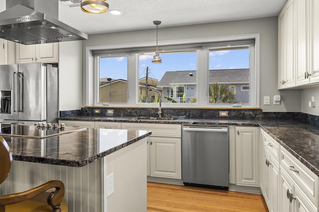 kitchen featuring sink, plenty of natural light, white cabinetry, island exhaust hood, and stainless steel appliances