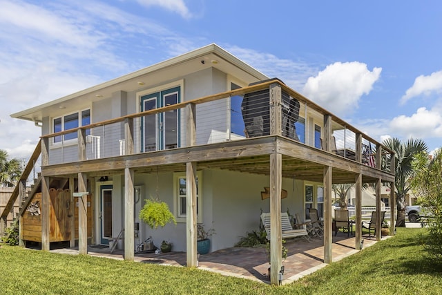 rear view of house with a yard, a deck, and a patio area