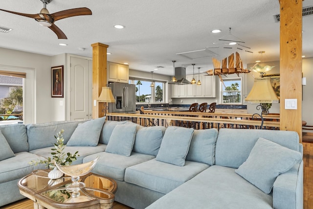 living room featuring a textured ceiling, light hardwood / wood-style flooring, and plenty of natural light