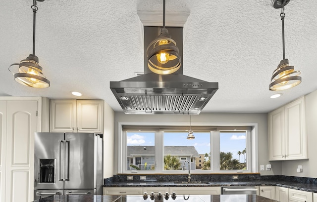 kitchen featuring a textured ceiling, sink, stainless steel appliances, and hanging light fixtures