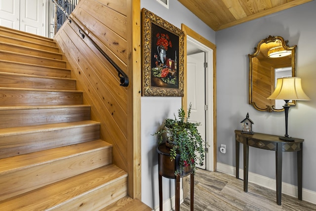 staircase featuring hardwood / wood-style floors and wood ceiling