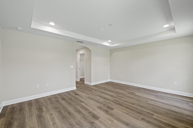 45 Laguna Forest Trl, Palm Coast, FL 32164 - spare room with a tray ceiling, arched walkways, recessed lighting, baseboards, and wood finished floors