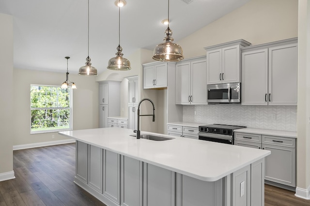 45 Laguna Forest Trl, Palm Coast, FL 32164 - kitchen with appliances with stainless steel finishes, a sink, decorative backsplash, light countertops, and a kitchen island with sink