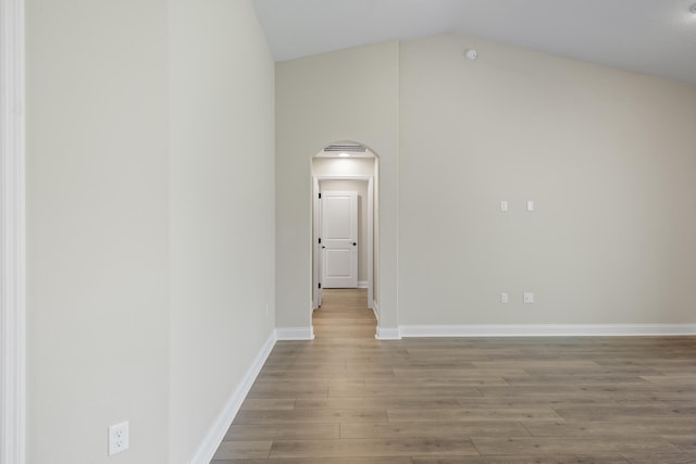 45 Laguna Forest Trl, Palm Coast, FL 32164 - unfurnished room featuring arched walkways, wood finished floors, vaulted ceiling, and baseboards
