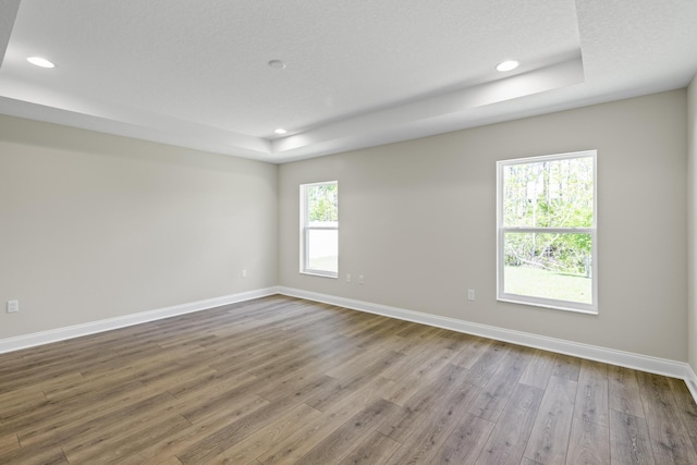 45 Laguna Forest Trl, Palm Coast, FL 32164 - empty room with a tray ceiling, wood finished floors, baseboards, and recessed lighting