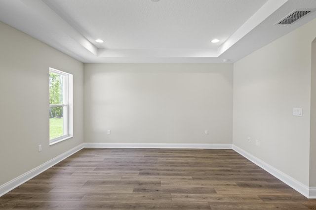 45 Laguna Forest Trl, Palm Coast, FL 32164 - empty room featuring a raised ceiling, dark wood-style floors, recessed lighting, and baseboards