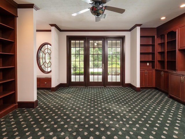 entryway featuring dark carpet, ceiling fan, and ornamental molding