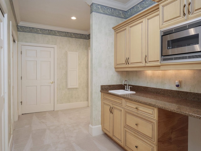 kitchen featuring light colored carpet, stainless steel microwave, ornamental molding, and sink