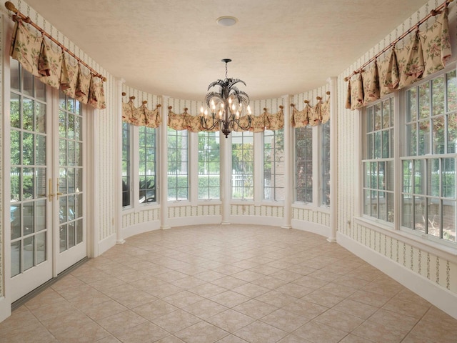 unfurnished sunroom featuring a notable chandelier and plenty of natural light