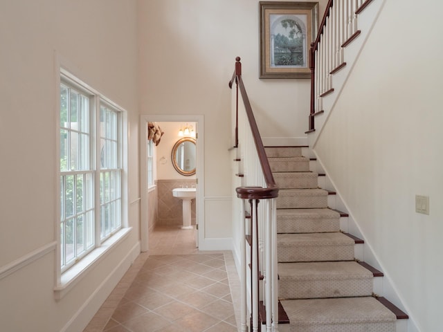 stairway with tile patterned floors and sink