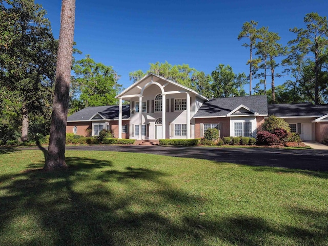 greek revival house featuring a front yard