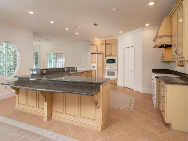 kitchen featuring a kitchen bar, custom range hood, white appliances, a spacious island, and light tile patterned floors