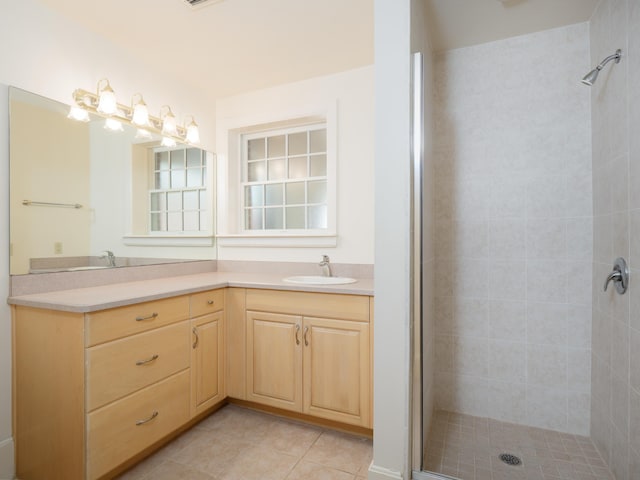 bathroom featuring tiled shower, vanity, and tile patterned floors