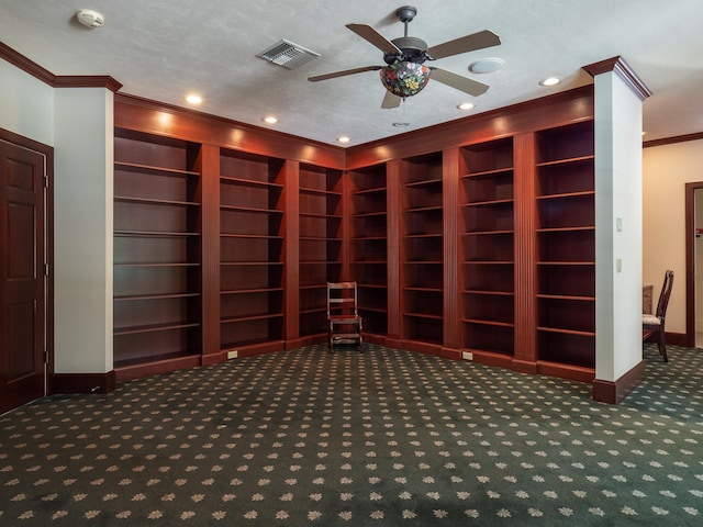 unfurnished room featuring a textured ceiling, dark carpet, ceiling fan, and crown molding