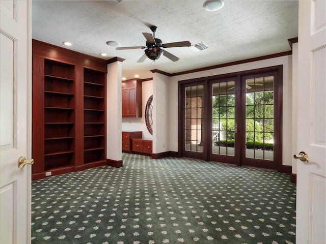 entryway featuring ceiling fan, dark carpet, ornamental molding, and a textured ceiling