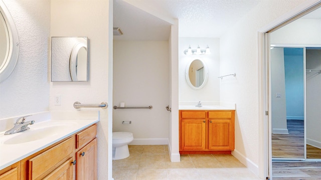 bathroom with tile patterned floors, vanity, toilet, and a textured ceiling